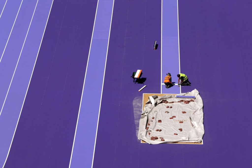 Stadium staff work on the long jump track inside the Stade de France.PHOTOGRAPH: RICHARD HEATHCOTE/GETTY IMAGES